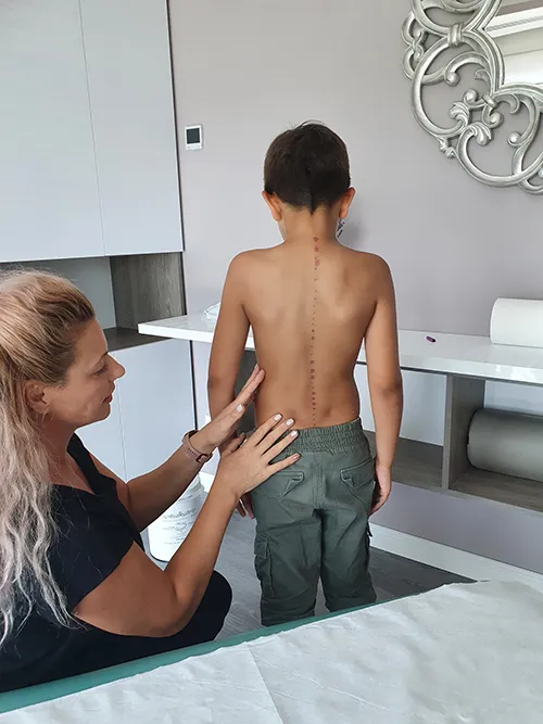 Copil folosind un aparat pentru recuperare medicală